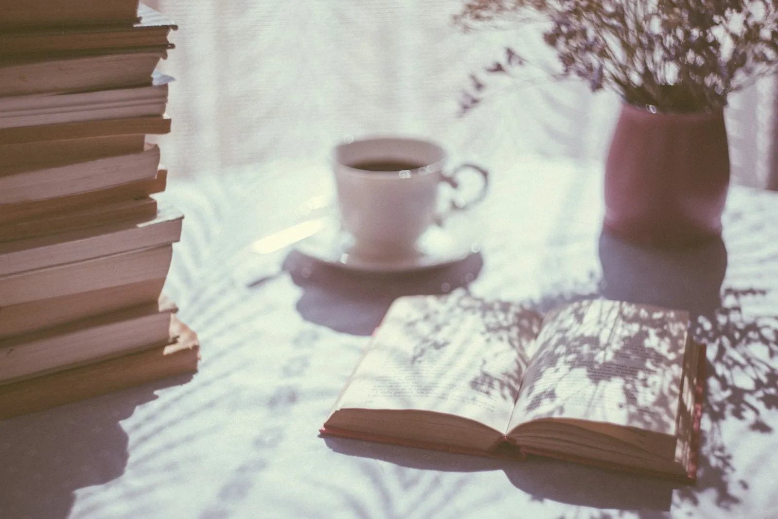 An open book next to a cup of tea