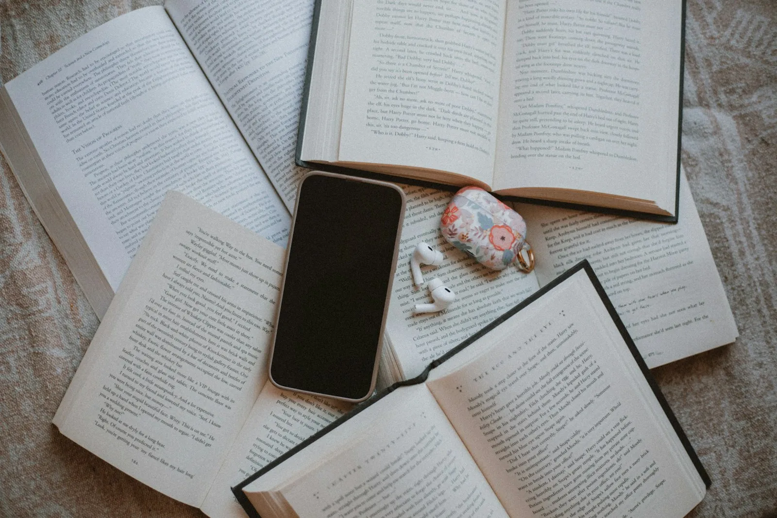 Open books, a phone and earbuds